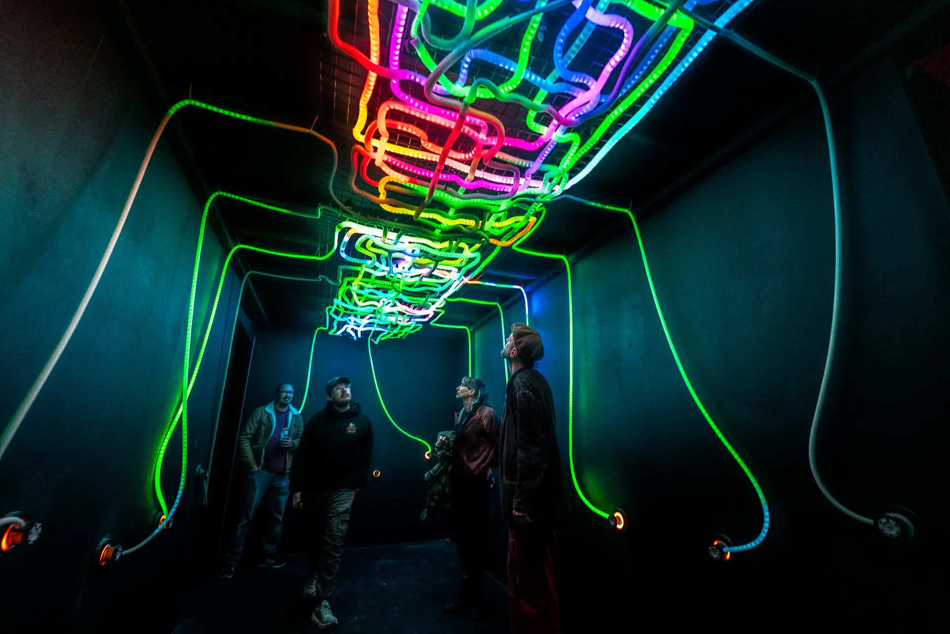 Wide shot of participants connecting illuminated cables across the Connect installation wall