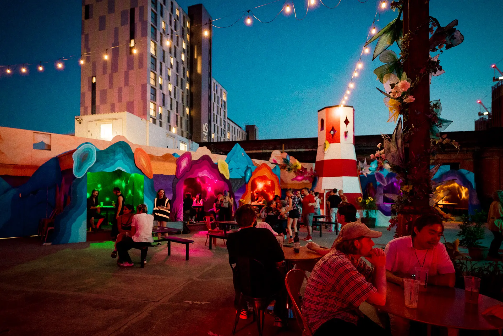 Exterior courtyard at Supermassive Manchester with illuminated structures and evening ambience