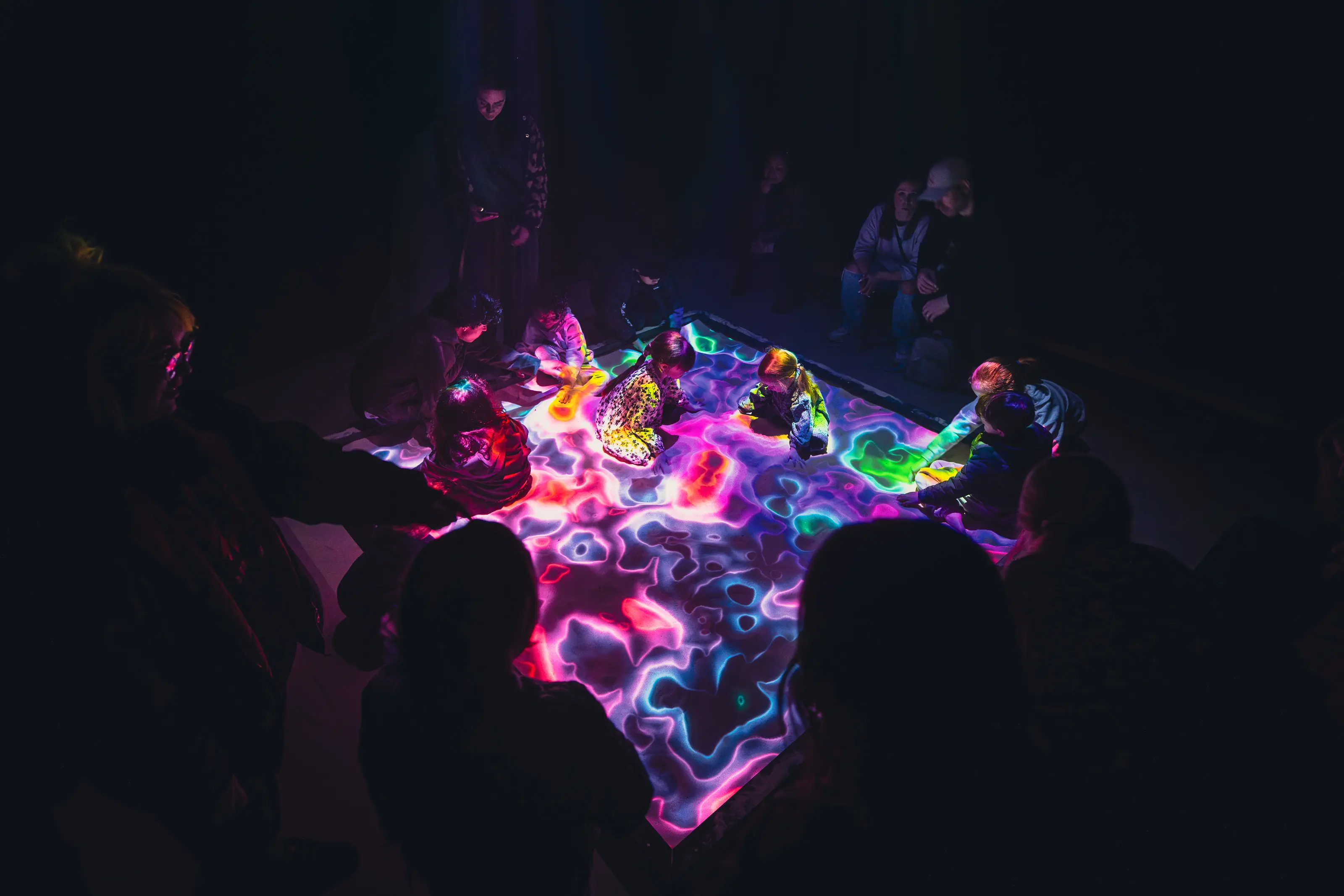 Group interaction moment demonstrating multi-generational engagement with the futurist playground